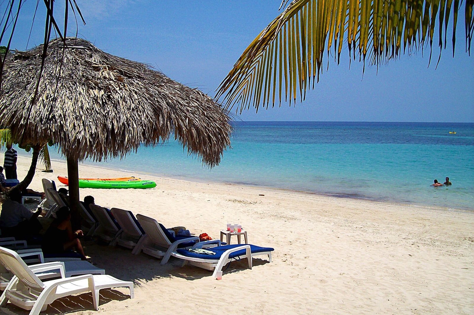 Palm-thatch umbrella and loungers at West Bay Beach